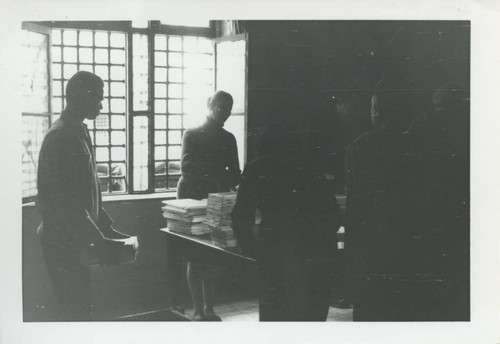 People standing around a table with Nag Hammadi codices