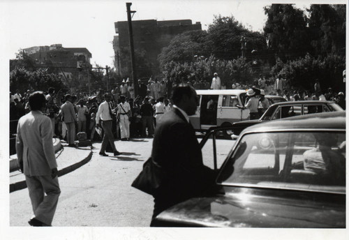 A street crowd watches Henry Kissinger's arrival at the Coptic Museum