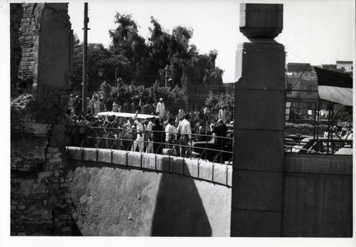 People in the street watch as Henry Kissinger arrives at the Coptic Museum