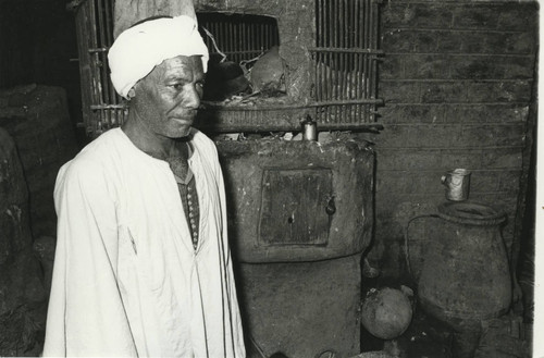 Muḥammad 'Alī Khalīfah al-Sammān next to outdoor stove