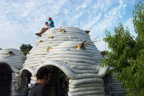 Students sitting atop unfinished Earth Dome beneath clouds