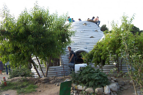 Students sitting atop unfinished Earth Dome with backs to camera