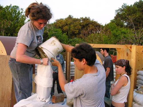 Student pouring dirt from bucket