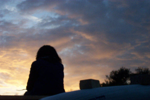 Silhouette of person looking at clouds