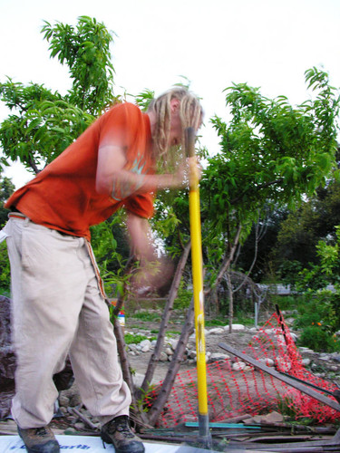 Student uses tamp at earth dome