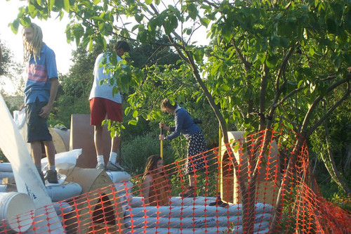 Student behind orange fence uses tamp