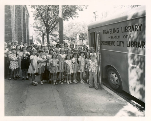Children stand outside Sacramento City Library bookmobile