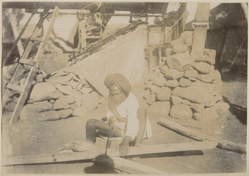 [Indian laborer sawing wood at base of the Pierson telescope in Camp Pierson, Wangi, India]