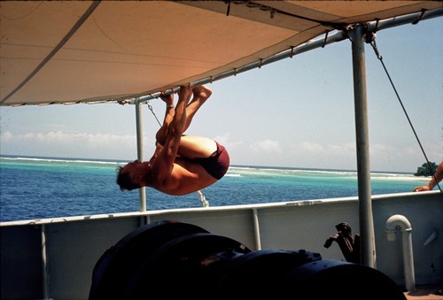 George Hohnhaus of Scripps Institution of Oceanography swinging from the cover of a boat