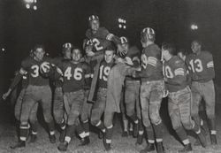 Football player Terry Bell being carried by team mates, 1948 — Calisphere