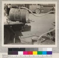 Set-up to show operation of the tractor tank filler. A safe method of filling tractor tanks in field by suction from the engine. 1930