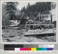 Redwood Region. Chris Gilson's operation on lower Turraw Creek. Klamath River, near Klamath, California. Ripped redwood logs on ground and on mill deck. Shovel used temporarily to lift ripped logs to deck. 8/17/48. E.F