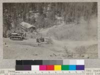 Penman Peak Lumber Company near Blairsden, showing two Best-60 tractors on the Highway which they cross to skid logs from the hill in foreground to the sawmill across the road and left of the picture. Note dusty character of road. E.F. August 1925. 4.3243