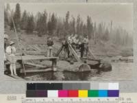 A group of the Camp Califorest class of 1926 on the catamaran of the Spanish Peak Lumber Company watching the unloading of logs at the log dump. The tackle in the right background is portion of an aerial system for decking logs in the pond for late fall. The "young lady" at the left is not a member of the party