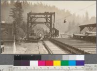 Method of unloading trucks from sorting table. Note turntable transfer cars. Hydraulic lift. Note also string of lights for night operation. Northwestern Lumber Company, near Willits, California. April, 1920. E. F