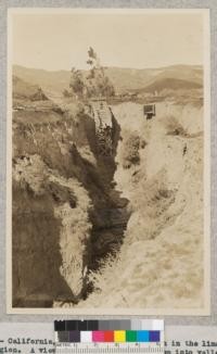 No. 12 - California, Ventura County. Erosion in the lima bean region. A view into a gully 84 feet deep into valley fill resulting from accelerated erosion from cultivated slopes. The large flume at the end of the gully was constructed to spill drainage beyond the gully walls and prevent head cutting to protect bridge. 1932 - W. C. Lowdermilk