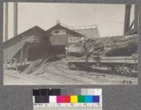 Bucking a sinker log on the car in front of Mill, Union Lumber Company, Fort Bragg. Note how cars can be run between two log decks with these sinker logs