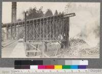 Open burner close to mill of Caspar Lumber Company, Caspar, California. Note brick protecting wall. May, 1920. E.F