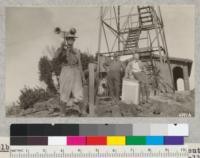 Mr. Gray of the Weather Bureau with Reuter, Jordan, and Malmsten assisting in installing fire weather instruments on Grizzly Peak, Berkeley Hills. Fire tower and house in the background. Sept. 1927. Metcalf