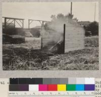 Redwood crib construction, fire test. Built of 2 x 6 laid flat and nailed. Burned all night without burning through. Tested by California Redwood Association at E. K. Wood Lumber Company's Oakland yard. Start of test. See also #5740. April, 1934. E. F