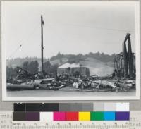 Remains of Sage Land & Lumber Company sawmill at Willits, California. Burned Aug. 23, 1945. First started along line shaft, near noon and spread rapidly. In a few hours, mill was wrecked. Boiler house to right; mill to left; burner to rear center, sorting table paralleled roadway. 8/28/45. E. F