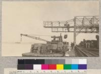 Coos Bay Lumber Company, Baypoint, California. Forestry class observing loading of a barge for Bay delivery. The two gantry cranes have 2 carriages each, and in unloading a vessel can handle 200,000 board feet per hour. Oct. 1923