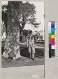 Dr. George P. Burns of Vermont and large cork oak on grounds of Napa State Hospital. Metcalf