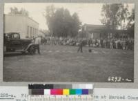 Fire Protection Demonstration at Merced County High School April 1942. Fire Warden Barry Dallas shows how to work on a dummy bomb. Metcalf