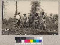 C.S. Dunwoody, Lookout Leyval, M.B. Pratt, L.E. Holland and Fowler at Sunset Peak lookout during a visit of State Forester's party of inspection. This lookout can see most of the lower timberland of southern Butte County, some of which is in the background. Visibility was improved by felling timber to the north and west which is being made into wood