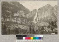 Yosemite Falls from the meadow below the old village. When a heavy wind is blowing the spray is blown about so that it resembles a cloud of smoke. Metcalf, 1925