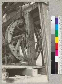 A "plain" bull wheel. The face of this bull wheel is flat and carries a flat brake band. The grooved bull wheel is in the background to the left on the other end of the same shaft. This picture shows the octagonal hub, the spokes and the segmental rim. Bakersfield, California. December, 1927