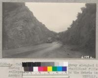 Cuts on the Angeles Crest Highway sloughed in during the heavy rain and the unstabilized fills collapsed in many places to add to the debris in Arroyo Seco Creek. March 1938. Metcalf