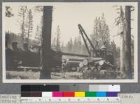 Loading flat cars with McGiffert jammer near Delliker. Putting the top log or binder, on first car. Note crotch line, Shay locomotive with homemade spark arrester - Feather River Lumber Company