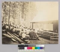 Camp Califorest. Waldo Wood gives the class a talk on grazing administration with the office wall as his blackboard. Not in good focus. 6/27/36 E.F