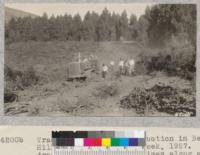 Tractor fire line construction in Berkeley Hills, Fire Prevention Week, 1927. After tractor had gone three times along a course it was almost wide enough for a road. Metcal. October 1927