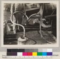 Proper method of draining gasoline from a storage tank. Metal lined hose. 1930