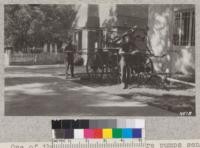 One of the first three hand fire pumps sent from Boston around the Horn to California. This in Weaverville with Inspector Strickland and Ranger Young. Metcalf. 1928