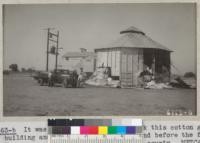 It was necessary to almost wreck this cotton gin building and pull cotton out on ground before the fire could be completely put out. Tulare County. Metcalf