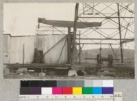 A wooden walking beam at a steel derrick. All other parts are of steel. In many cases steel walking beams are used in connection with steel derricks. Bakersfield, California. E. Fritz. December, 1927