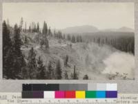 Penman Peak Lumber Company near Blairsden, California, showing the Quincy-Portola road and trails left by tractors used in yarding. Picture shows rough and steep hillsides, some of them 30-50%, over which the tractors operate. Smoke in the foreground is from the sawmill refuse heap