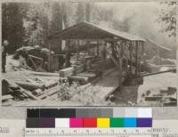 A small sawmill on Bull Creek, Humboldt County, California (Danielson & Turner) above the Albee Ranch, 5000 board feet per day. Three men. Picture shows 3, 4" cants being run through headsaw (a single circular) to make 2x4's. See also #2101. Cutting D. F. June, 1922. E. F