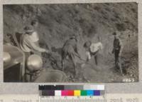 Forest rangers doing a little road work on Silverado canyon road during Orange County Forestry tour in 1931. Washed by first fall rain. W. Metcalf - Oct. 1931