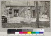 Camp Califorest - Cabin. At spring of camp May 1922. Note snow bank. Metcalf, Schumacher & Mrs. Schumacher. Beatrice Metcalf in barrow