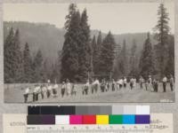 The funeral of "Miss Information" - grand-daughter of General Disorder - by the Kings-Tulare 4-H girls. Liberal quantities of earth and rocks were heaped on the grave. "Whitaker's Pride" group of trees in the background. Metcalf. July, 1928