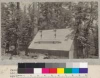 Package of lumber in tramway of Spanish Peak Lumber Company, Plumas National Forest, California, silhoutted againast roof of horse-barn at their "Angle Station" camp. Each package contains 300-350 feet