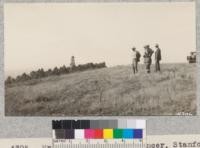 Mr. Geo. Foley with Spencer, Stanford and Pemberton on the ridge of hills, Murphy Ranch, Whittier, discussing the planting plans. Sugar gum Eucalyptus grove in the background. November, 1927. Metcalf