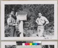 Steele and Zivnuska look at data in one of the field boxes at the demonstration plot. Wind River, Washington. These plot markers protect the data from the weather