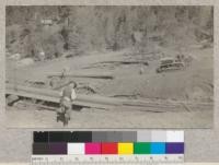 Penman Peak Lumber Company, Teeter and Rowe, near Blairsden, California. Photograph shows a Best-60 tractor dragging a log to the dry landing chute in which the logs are taken into the mill. E.F. August 1925. 4.3243