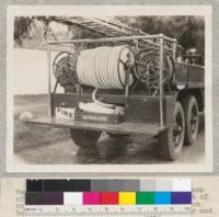 Rear view of the new 6-wheel rural fire truck of Riverside County, October 1930. Details of hose reels and rear compartments. Drives on both sets of rear wheels giving greater power and traction in soft going. Fairbank