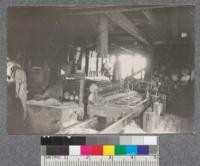 Interior of saw mill cutting White Pine on St. Croix River at Baring, Maine. Logs very small. Sometimes sawed one on top of the other as in this picture. Carriage very light. D.T. Mason 1919